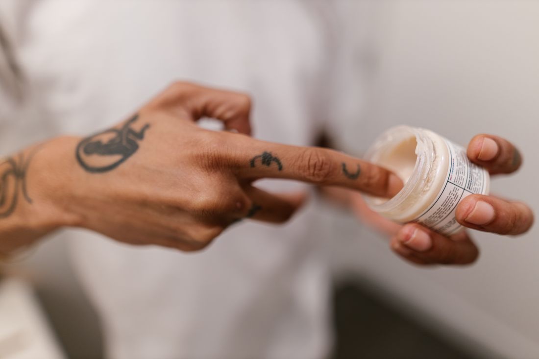 Mãos aplicando creme manipulado