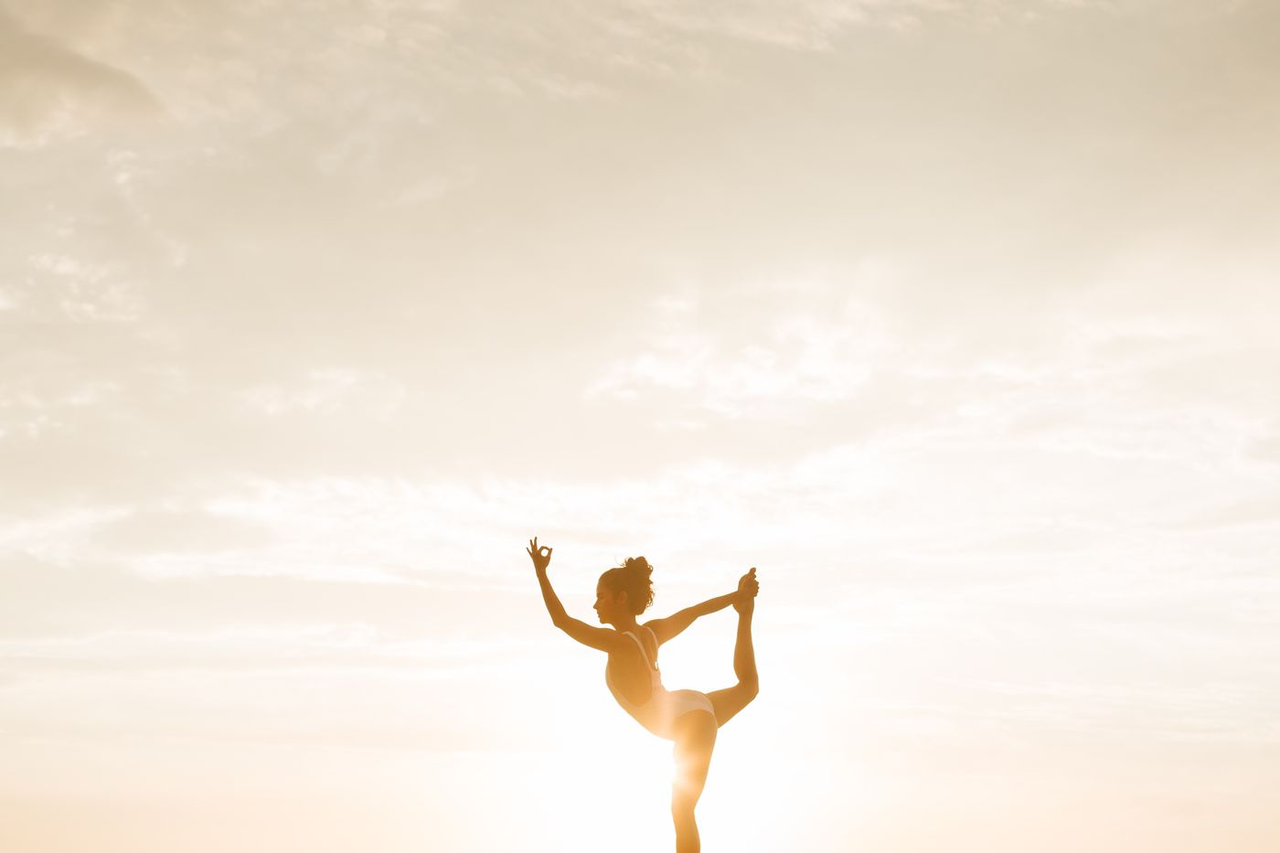 Silhueta de mulher praticando yoga ao pôr do sol